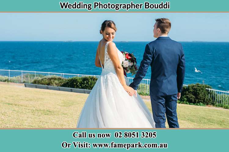 Photo of the Bride looking at her back as the Groom hold her hands Bouddi