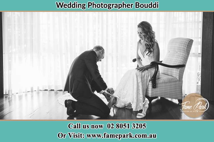 The Bride is being helped by the Groom trying to put on her shoes Bouddi