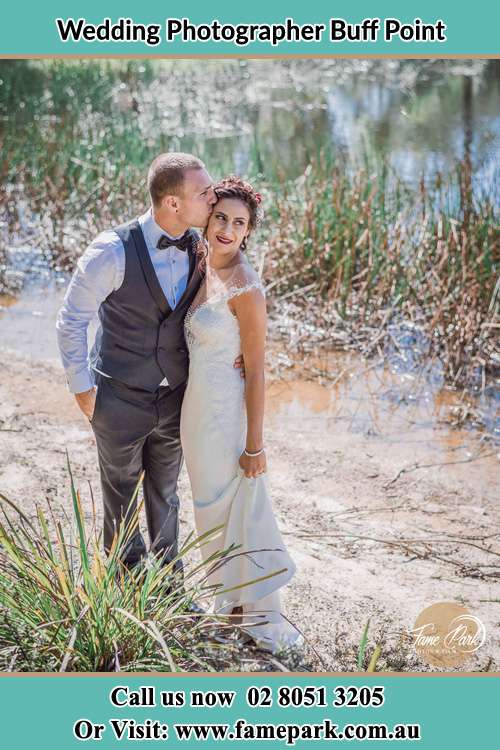 Photo of the Groom kiss the Bride near the lake Buff Point NSW 2262