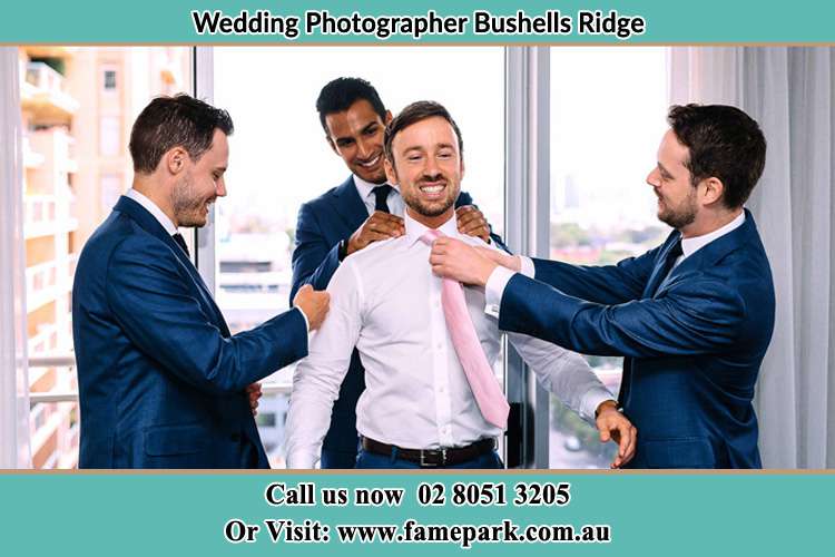 Photo of the Groom helping by the groomsmen getting ready Bushells Ridge NSW 2259