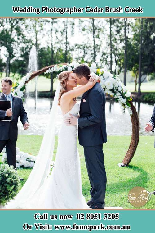 Photo of the Bride and the Groom kiss at the wedding ceremony Cedar Brush Creek