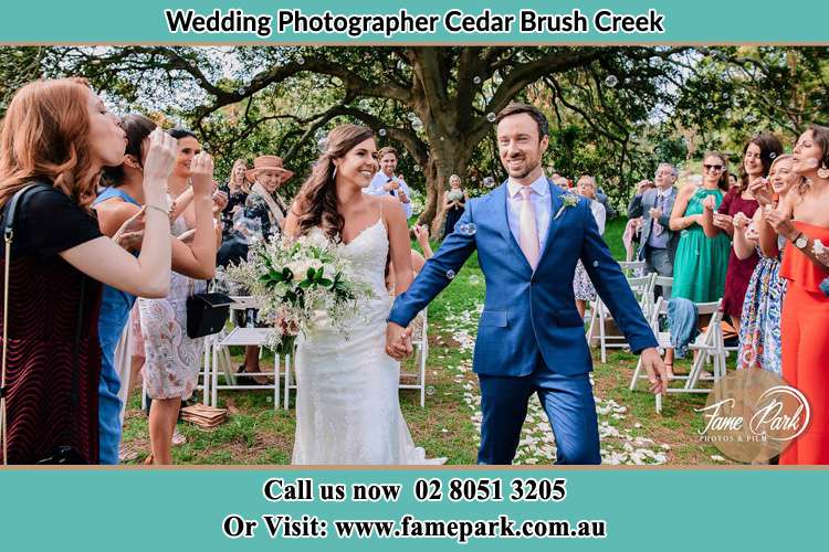 Photo of the Bride and the Groom showering bubbles by the visitors Cedar Brush Creek NSW 2259