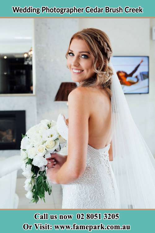 The Bride holding flower and smiling on the camera Cedar Brush Creek NSW 2259