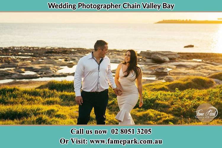 Photo of the Groom and the Bride walking near the lake Chain Valley Bay NSW 2259