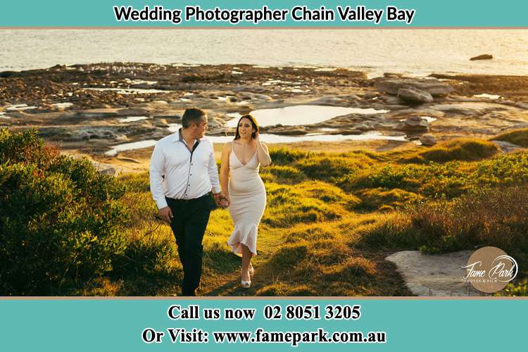 Photo of the Groom and the Bride walking near the lake Chain Valley Bay NSW 2259