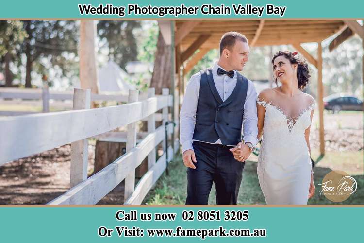 Photo of the Groom and the Bride holding their hands while walking Chain Valley Bay