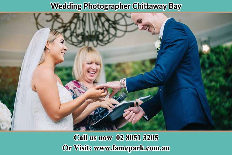 The Groom and the Bride holding their hands while the pastoress is watching Chittaway Bay