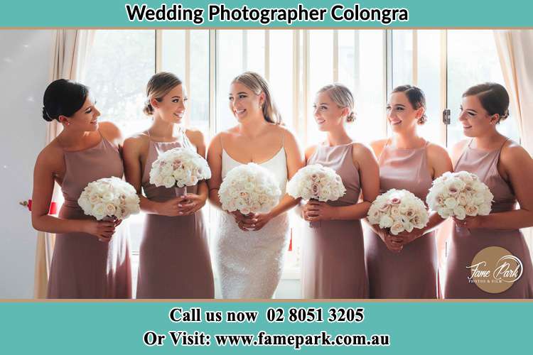 Photo of the Bride and her bridesmaids each holding a bouquet of flowers Colongra