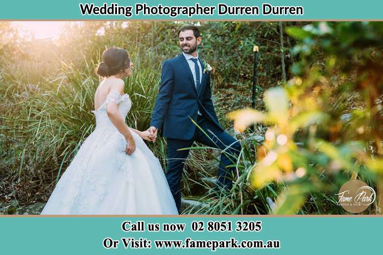 The Groom and the Bride hold their hands while looking at each other in the garden Durren Durren