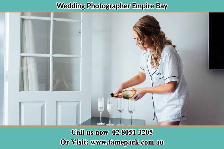 Photo of the Bride pouring wine the glasses Empire Bay NSW 2257