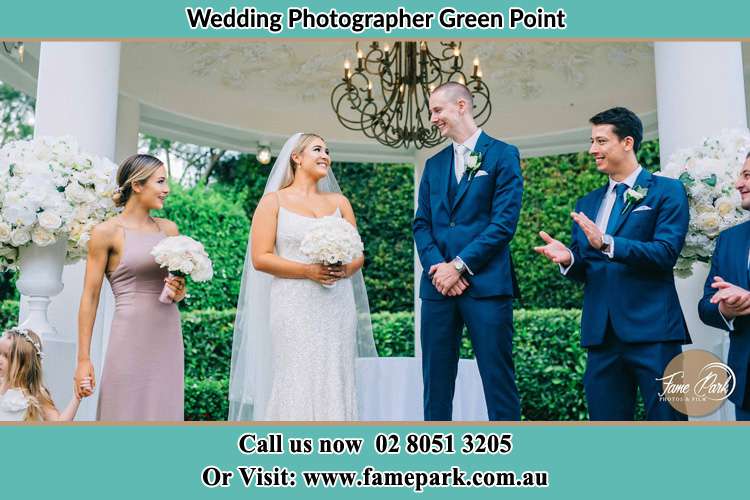 Photo of the Bride and the Groom happily looking each other with the entourage Green Point NSW 2251