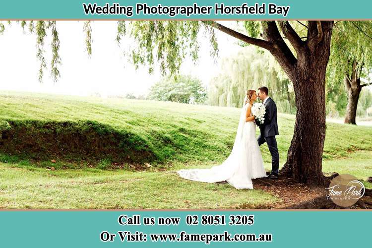 Photo of the Bride and the Groom kissing under the tree Horsfield Bay NSW 2256