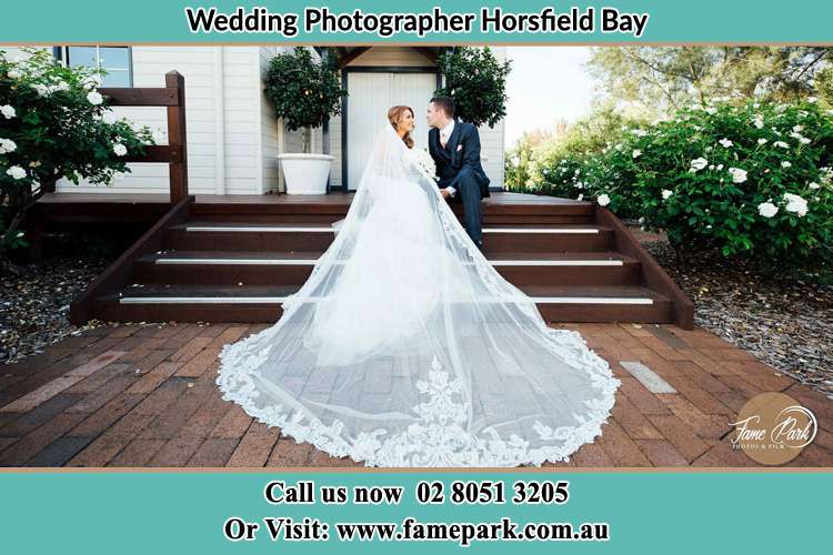 Photo of the Bride and the Groom looking each other while sitting at the staircase Horsfield Bay NSW 2256