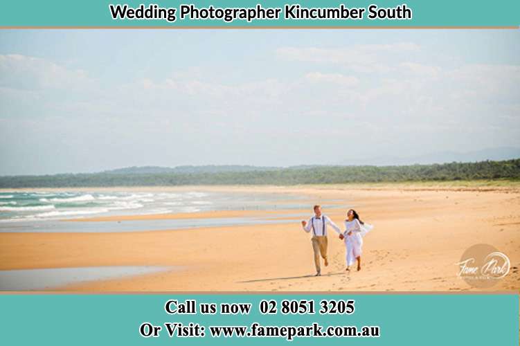 Photo of the Groom and the Bride walking at the sea shore Kincumber South NSW 2251