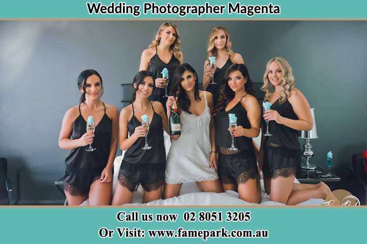 Photo of the Bride and the bridesmaids wearing lingerie and holding glass of wine on the bed Magenta NSW 2261