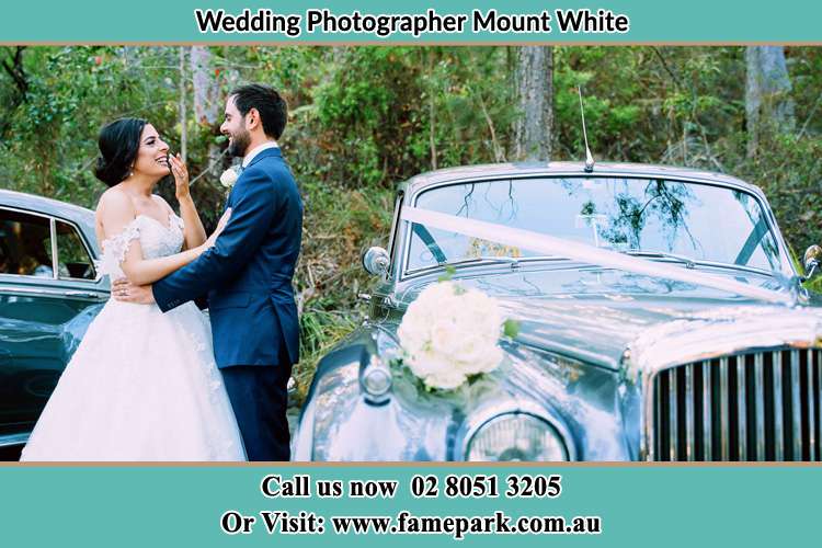 Photo of the Bride and the Groom besides the bridal car Mount White NSW 2250