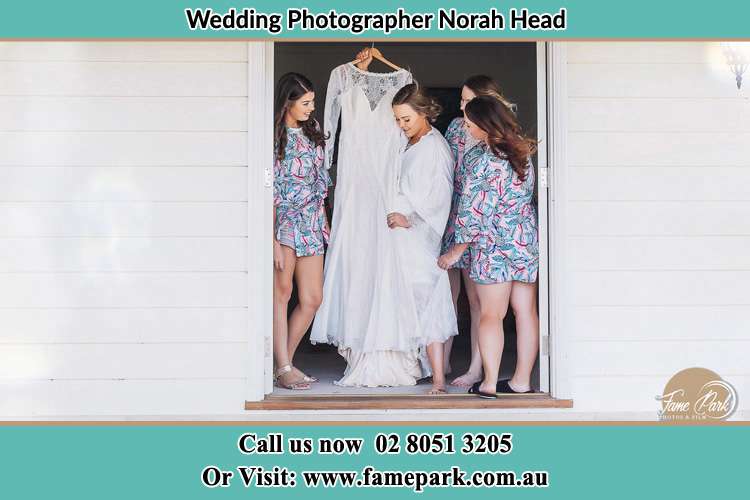 Photo of the Bride and the bridesmaids checking the wedding gown at the door Norah Head NSW 2263