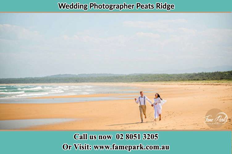 Photo of the Groom and the Bride walking down the sea shore Peats Ridge NSW 2250