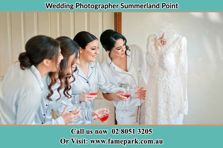 Photo of the Bride and the bridesmaids looking at the wedding gown Summerland Point NSW 2259