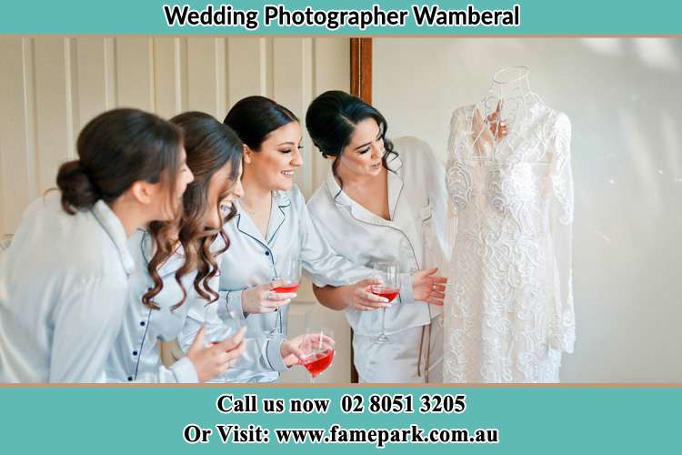 Photo of the Bride and the bridesmaids looking at the wedding gown Wamberal NSW 2260